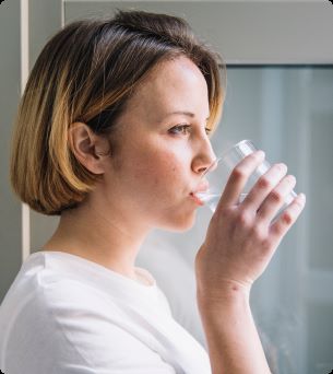 vrouw dringt glas met water