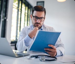 man kijkt naar papier achter zijn bureau