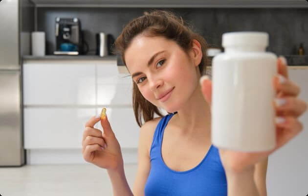 vrouw laat pot met pillen zien en heeft er ook 1 in haar hand