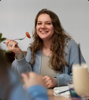 vrouw zit aan tafel lunch te eten